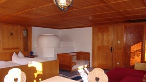A wooden-furnished room with a bed, a crib, and a table. - Vacation apartment 1, Haus Gabi Vacation with pets (Bad Hindelang)