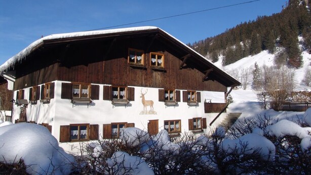 A multi-story wooden building with a sloped roof, surrounded by snow-covered trees and a clear sky. - Vacation apartment 1, Haus Gabi Vacation with pets (Bad Hindelang)