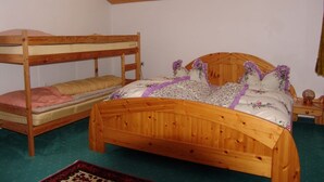 Una cama litera de madera con una cama inferior y una cama individual con ropa de cama estampada.