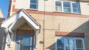 A two-story house with a brick facade, a front door, and a small porch. - Windy House (Sheffield)