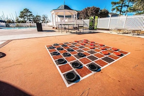 Un parque infantil con un juego de saltar por neumáticos, un pabellón y una zona vallada con bancos.