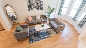 A living room with a grey sofa set, a coffee table, and a large mirror.