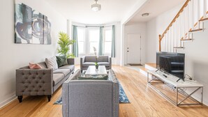 A modern living room with a sofa, coffee table, and TV on a stand.