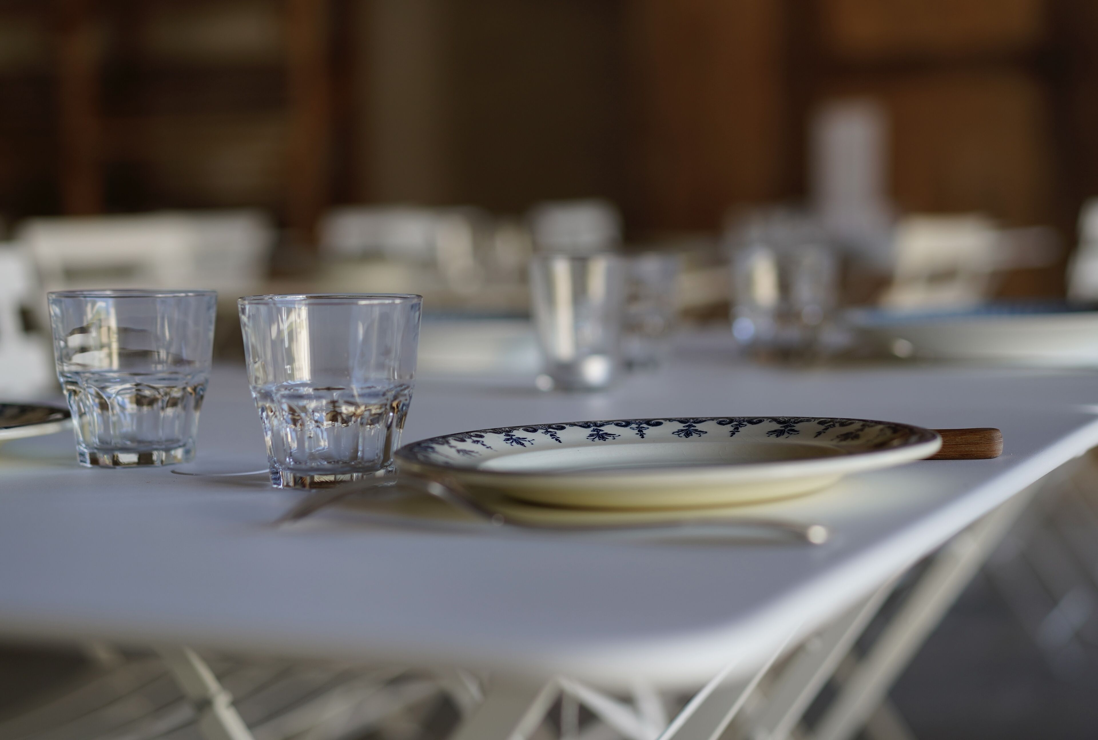A dining table with plates, glasses, and a knife.