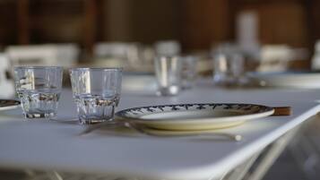 A dining table with plates, glasses, and a knife.