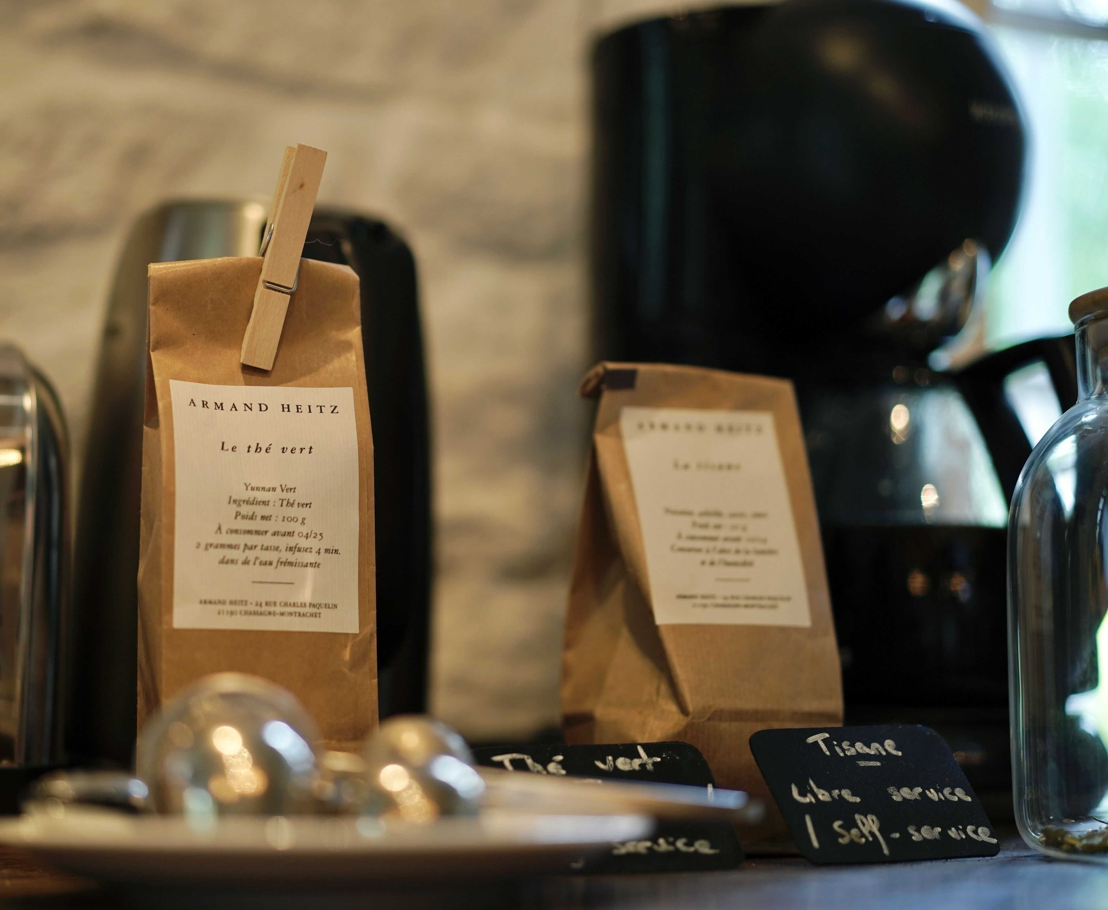 A coffee shop counter with bags of coffee and a glass jar.