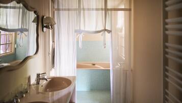 A bathroom with a sink, mirror, and bathtub.