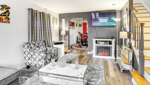 Un salon moderne avec un canapé à motifs, une table basse en marbre et une cheminée.