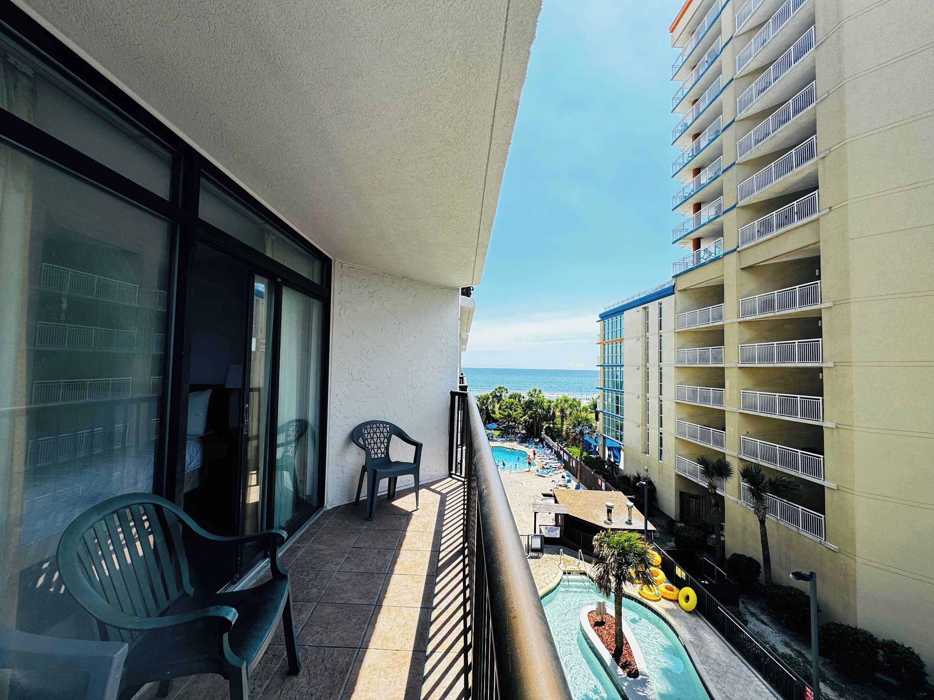 Ein Balkon mit Blick auf einen Pool und ein Gebäude mit Balkonen.