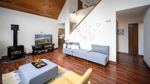 A living room with a fireplace, sofa, and television.