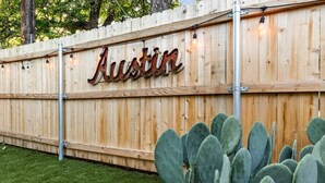 Una cerca de madera con el nombre 'Austin' en letras de metal.