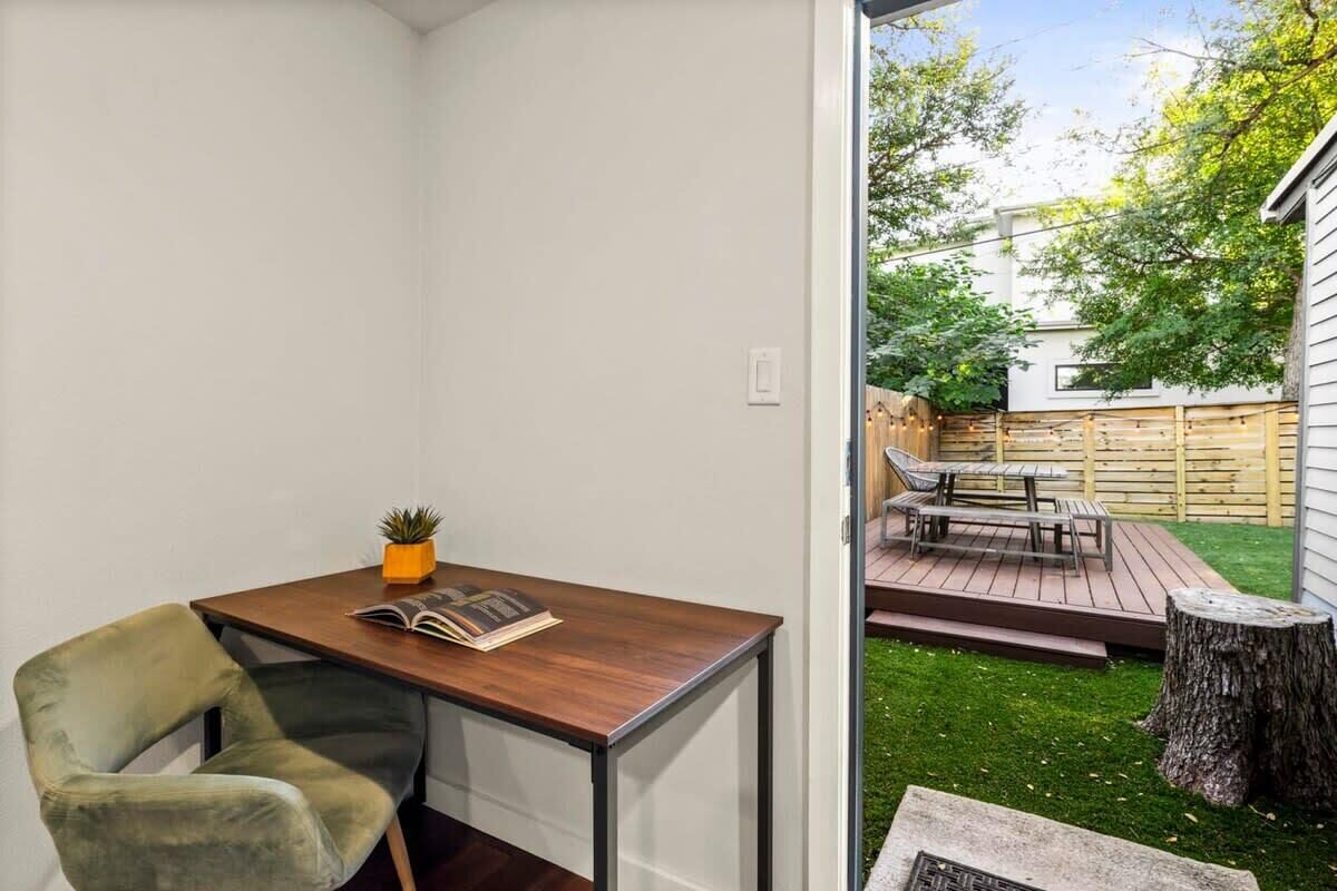 A room with a wooden desk, a green chair, a small potted plant, and a magazine.