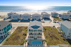 A beachfront hotel with multiple-story buildings, a swimming pool, and a beach view.