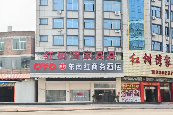 Un edificio comercial con varias tiendas, incluyendo un letrero visible de 'OYO' y otro del 'Dongnan Red Market Hotel'.