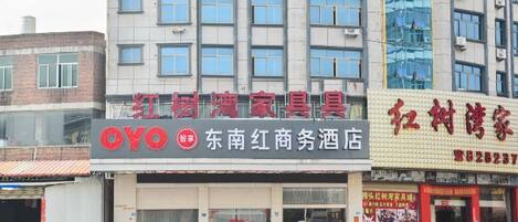 Un edificio comercial con varias tiendas, incluyendo un letrero visible de 'OYO' y otro del 'Dongnan Red Market Hotel'.