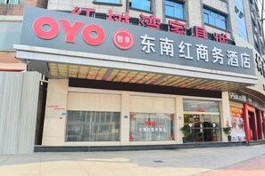 Un hôtel arborant un logo OYO bien visible et une signalétique indiquant qu’il s’agit d’un hôtel d’affaires situé à Dongguan, en Chine.