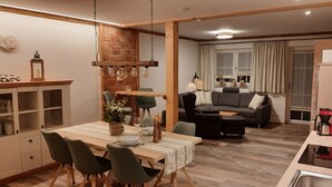 Un'area pranzo con un tavolo di legno, sedie e un lampadario.