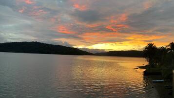 Een rustig meer bij zonsondergang, met een boot afgemeerd aan de oever.