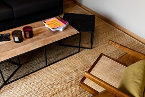 Relax in this inviting living area with a coffee table, woven rug, and comfortable chair.