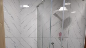 Ein Badezimmer mit Duschkabine, Toilette und Waschbecken.