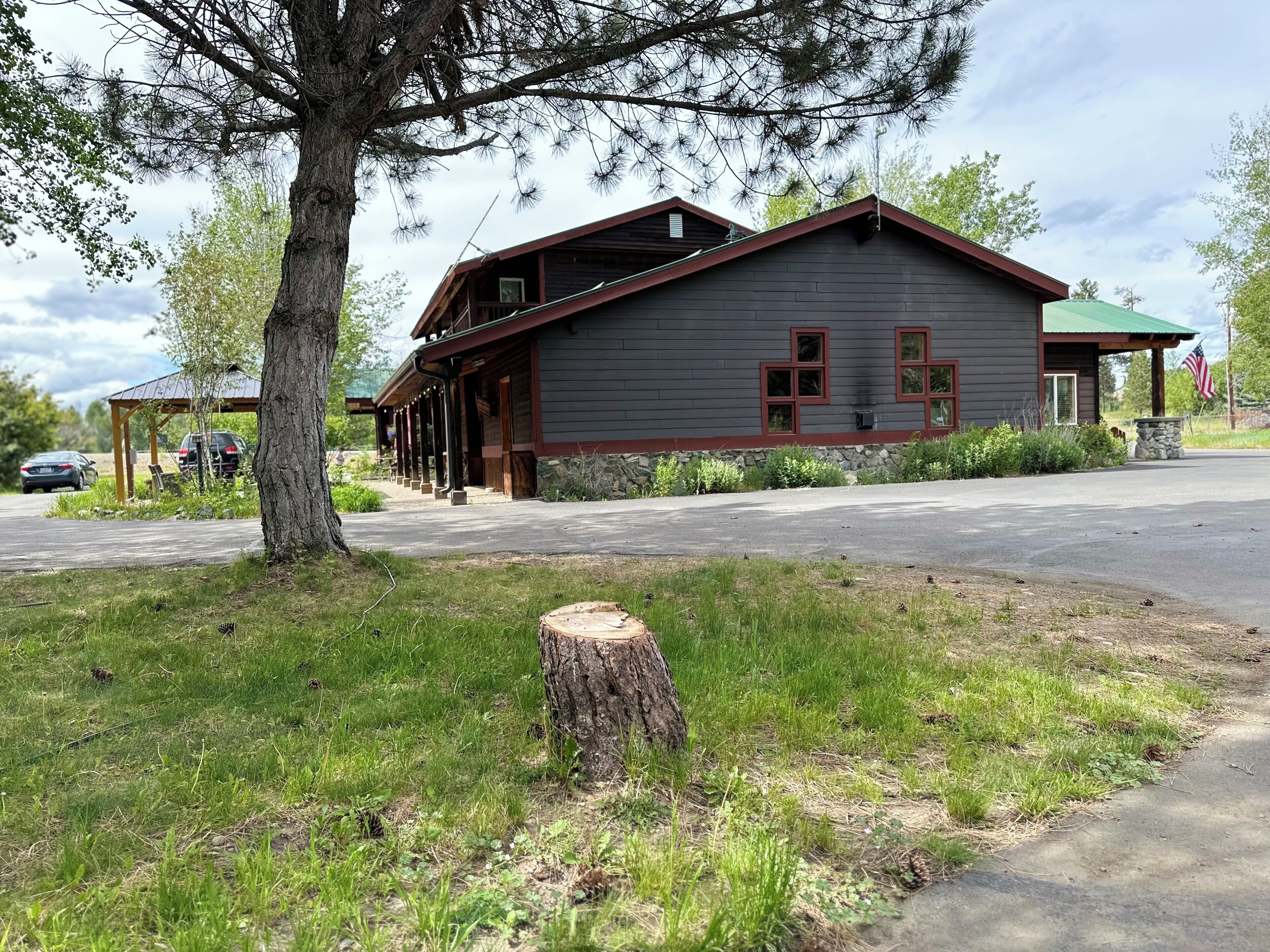 En stuga med en inglasad veranda, en grund av sten och en amerikansk flagga.