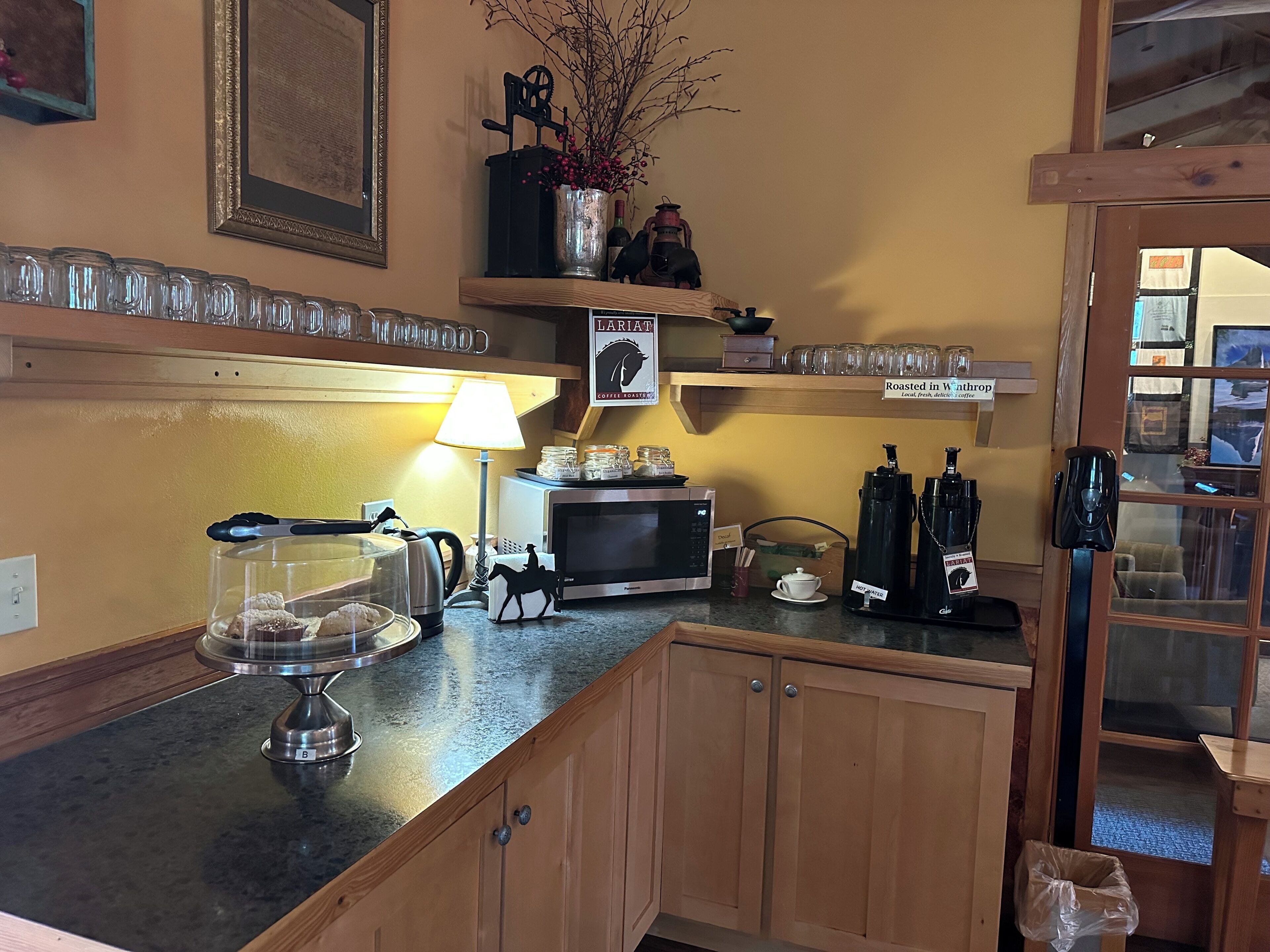 A kitchen with a coffee machine, a microwave, and a coffee press.