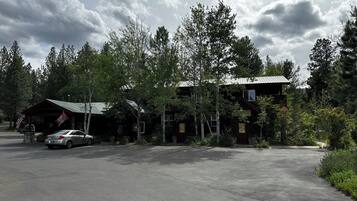 A lodge with a covered parking area, surrounded by trees.
