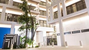 Un hôtel à plusieurs étages, doté d’un design moderne, avec des balcons et de grandes fenêtres.