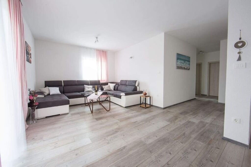 Una sala de estar moderna con un sofá modular, una mesa de centro y una mesita auxiliar.