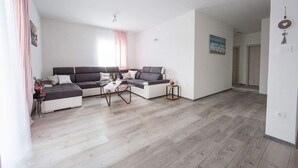 Una sala de estar moderna con un sofá modular, una mesa de centro y una mesita auxiliar.