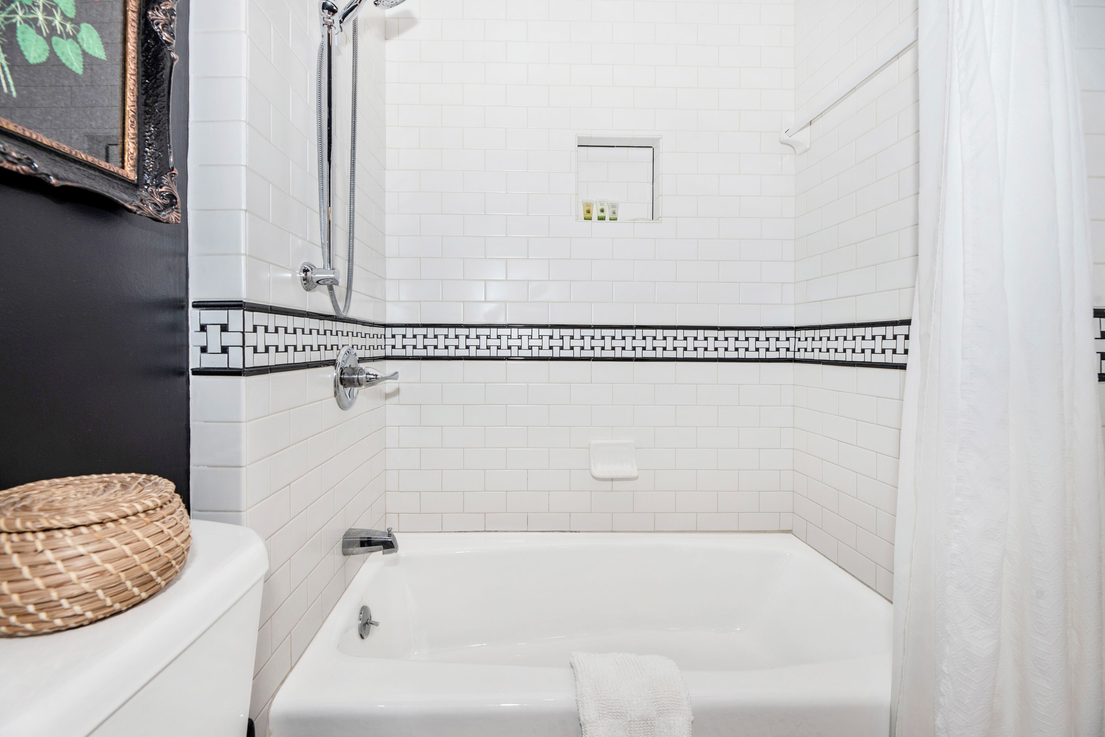 A bathroom with a white bathtub, a shower, and a toilet.