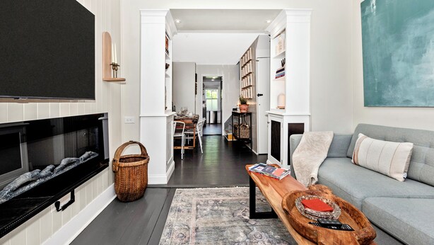 A living room with a fireplace, a sofa, a coffee table, and a bookshelf.