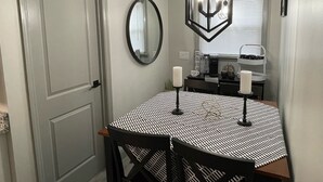 A dining area with a round table, chairs, a mirror, and a geometric pendant light. - 1st Floor Completely Remodeled, Pets Welcome!!! King & Queen Beds, W/D in Unit., (Monroe)