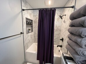 Bañera con ducha, secador de pelo, toallas, jabón