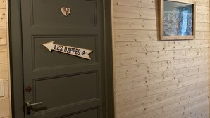 Una puerta verde oscuro con un adorno con forma de corazón y un letrero que dice "LES DAPPES".