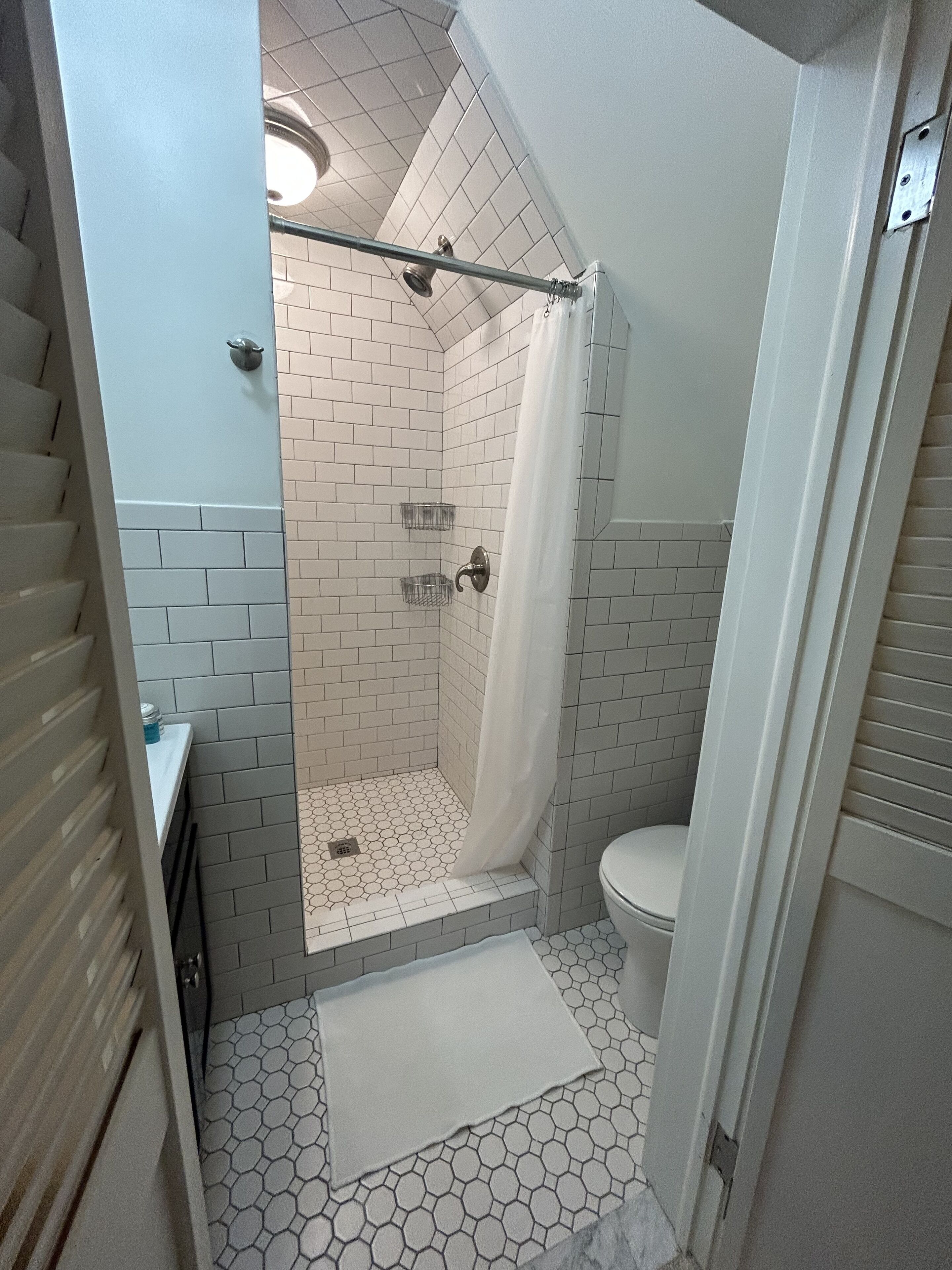 A bathroom with a shower, toilet, and sink.