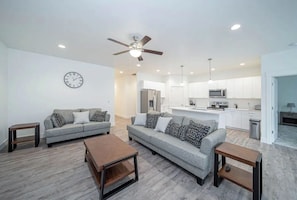 Relax in this stylish living area with a sofa set, wooden side tables, and a coffee table.