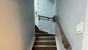 Uma escada de madeira com paredes brancas e um corrimão.