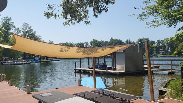 A dock with a covered seating area, a pool, and a building in the background. - Lakeside Waterfront: Private Dock - Near Lake Anna Winery (Bumpass)