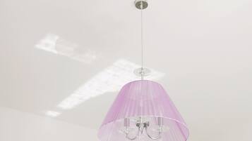 Luminária pendente com cúpula roxa e detalhes em cristal suspensa no teto.