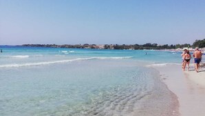 A beach with clear shallow waters and a sandy shore. - Calafatari B&B (Syracuse)