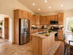 Une cuisine moderne avec des meubles en bois, des appareils en acier inoxydable et un îlot central.