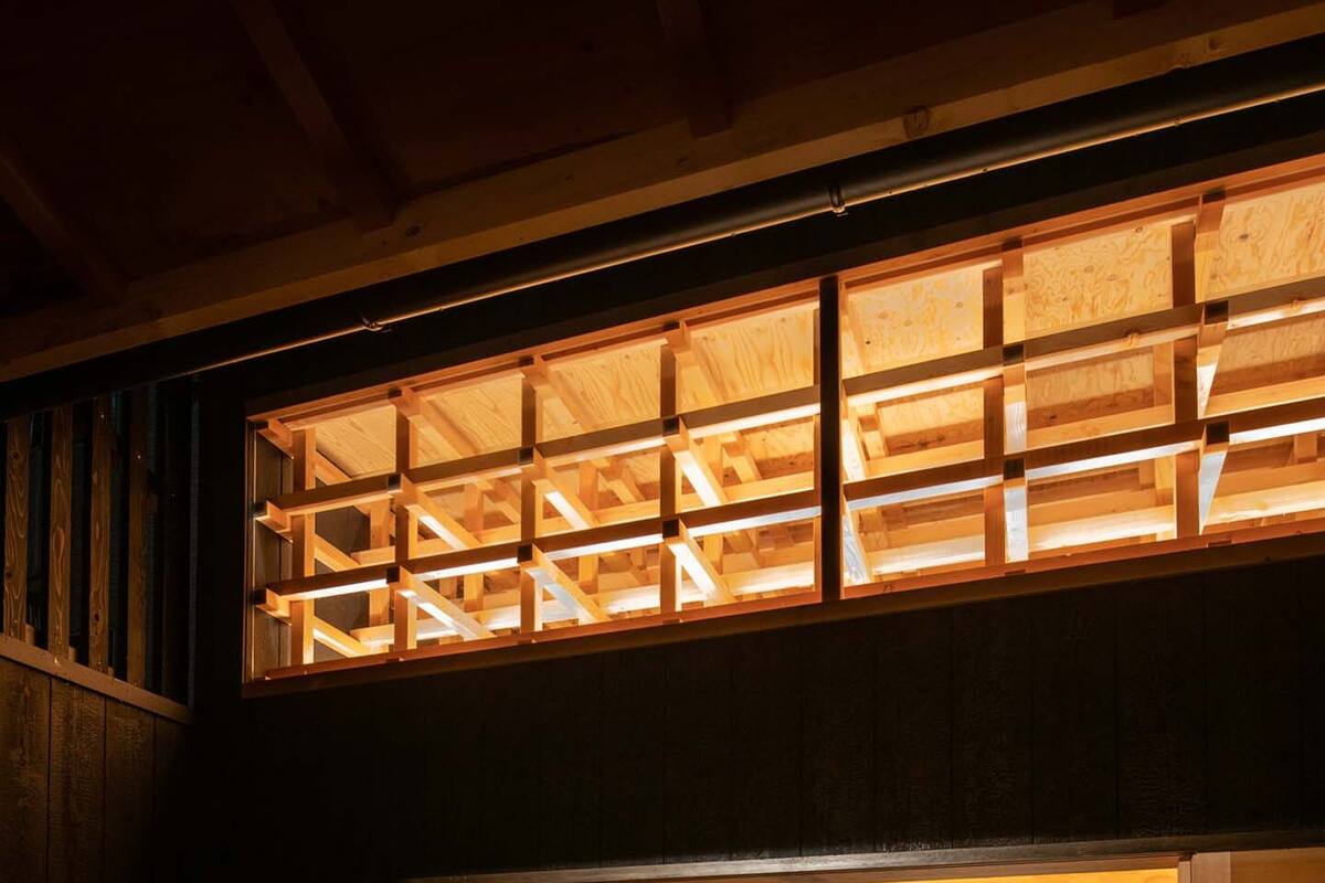 A two-story wooden structure with a bed on the lower level and a view of the night sky through the upper level.
