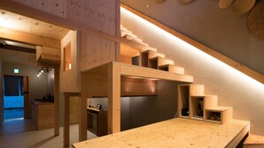 Un intérieur moderne en bois, comprenant un espace cuisine, des étagères intégrées et un escalier.