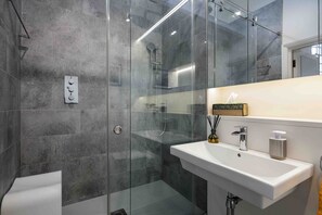 Bañera con ducha, toallas, jabón, papel higiénico