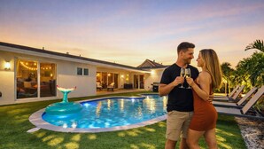 A swimming pool with a mermaid tail decoration, a house with a patio, and a sunset sky. - Family getaway • Pool • BBQ • Golf • BB Court (Miami)