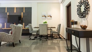 A modern dining area with a table, chairs, and a decorative mirror. - Gyamfuaa Court Apartment (Kumasi)