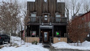 A two-story building with a sign reading "Connoisseur Pharmacies". - Connoisseur Hideaway (Bozeman)