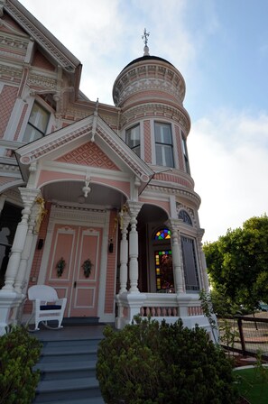 A historic building with a pink facade, white columns, and a distinctive tower. - Pinc Lady Mansion (Eureka)
