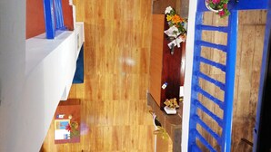 A spacious indoor area with wooden flooring, multiple potted plants, and a blue railing. - El Ave Azul Boutique Hotel Cusco (Cusco)